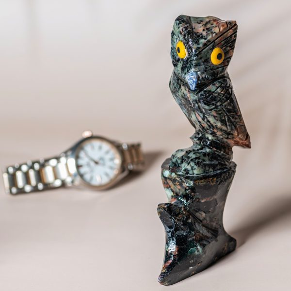 Semi precious stone owl sculpture shown with watch for size reference.