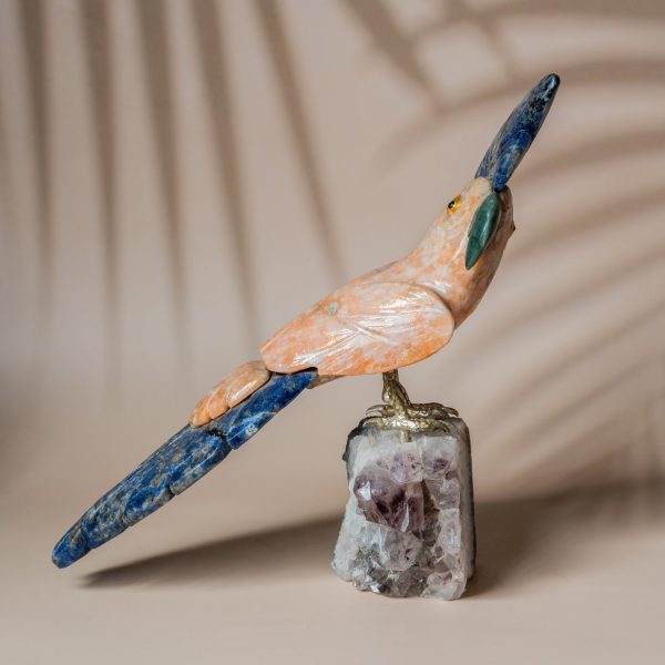 Handcrafted parrot sculpture in orange calcite and blue quartz perched on an amethyst geode, luxury decor and gifting piece by Artixle