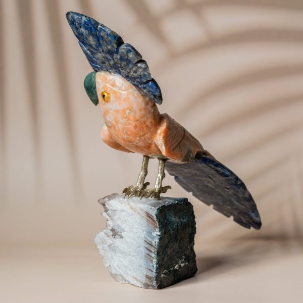 Handcrafted parrot sculpture in orange calcite and blue quartz perched on an amethyst geode, luxury decor and gifting piece by Artixle