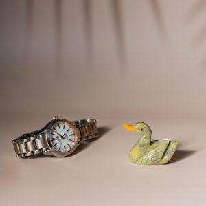 Handcrafted semi-precious stone duck figurine for home decor and gifting, shown with watch for size reference