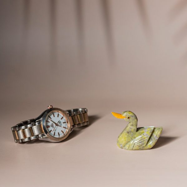 Handcrafted semi-precious stone duck figurine for home decor and gifting, shown with watch for size reference