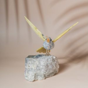 Hummingbird figurine in blue green sodalite with yellow wings on natural amethyst geode for home decor and gifting