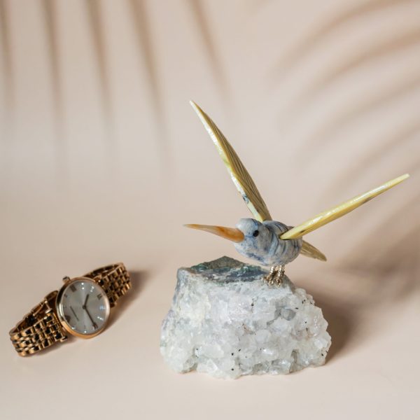 Hummingbird figurine in blue green sodalite with yellow wings on natural amethyst geode for home decor and gifting