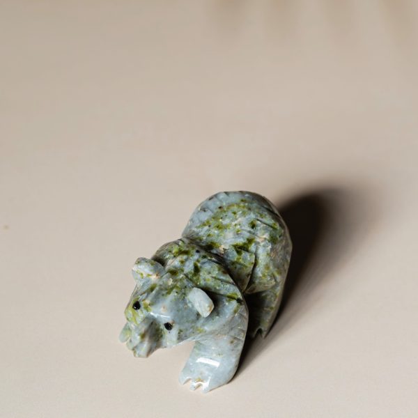 Side view of light green jade bear figurine carved from natural jade stone