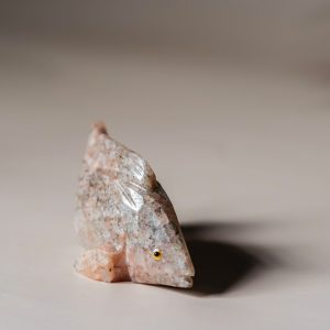 Hand-carved rose calcite fish figurine showcasing soft pink stone tones for home decor
