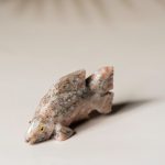 Hand-carved rose calcite fish figurine showcasing soft pink stone tones for home decor