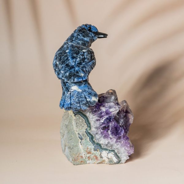 Handcrafted sodalite bird perched on natural amethyst geode decor piece