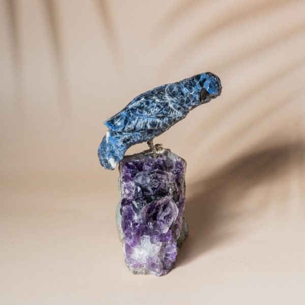 Handcrafted sodalite bird perched on natural amethyst geode decor piece