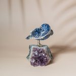 Handcrafted sodalite sparrow bird perched on natural amethyst geode base